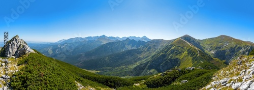 Extra wide panorama of High Tatra main ridge of mountains during summer with blue sky with clouds, Poland