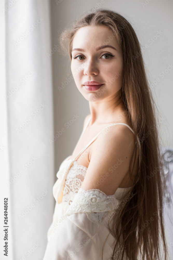 Attractive young seminude girl in night clothes posing sexually by the window Attractive young seminude girl in night clothes posing sexually by the window