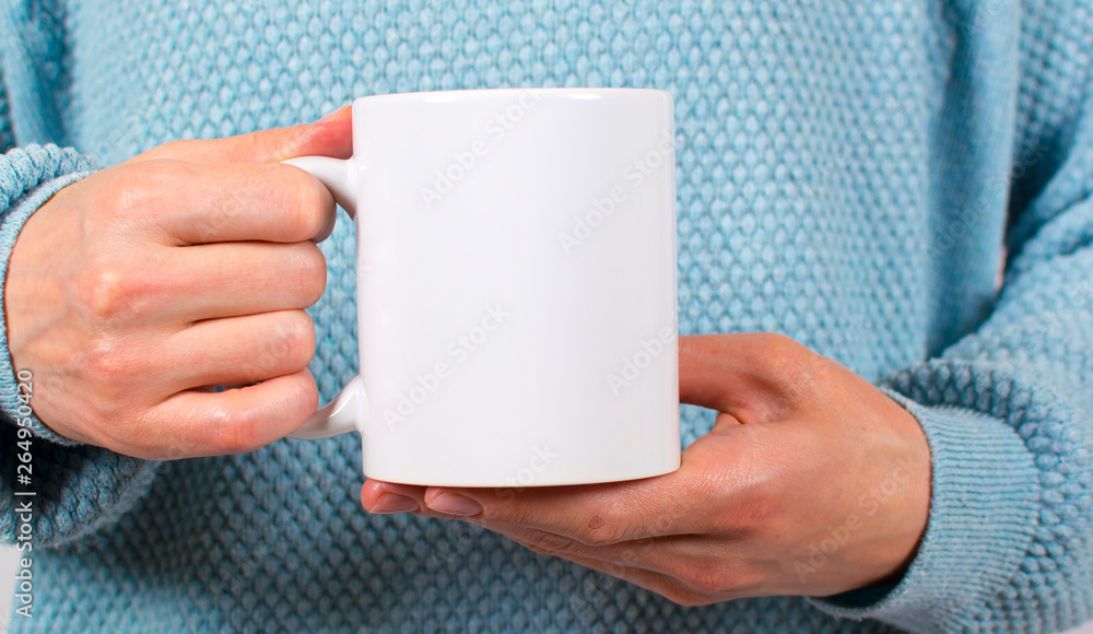 Hands of a young woman holding a Cup of coffee or tea. These mugs are used to apply the logo Hands of a young woman holding a Cup of coffee or tea. These mugs are used to apply the logo