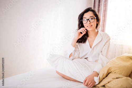 Beautiful Positive woman sitting in bed in morning