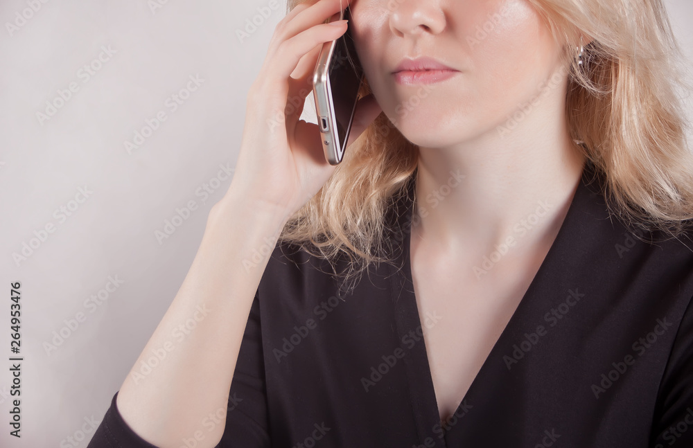 Fototapeta premium Young beautiful business woman holding phone and talk in the office.