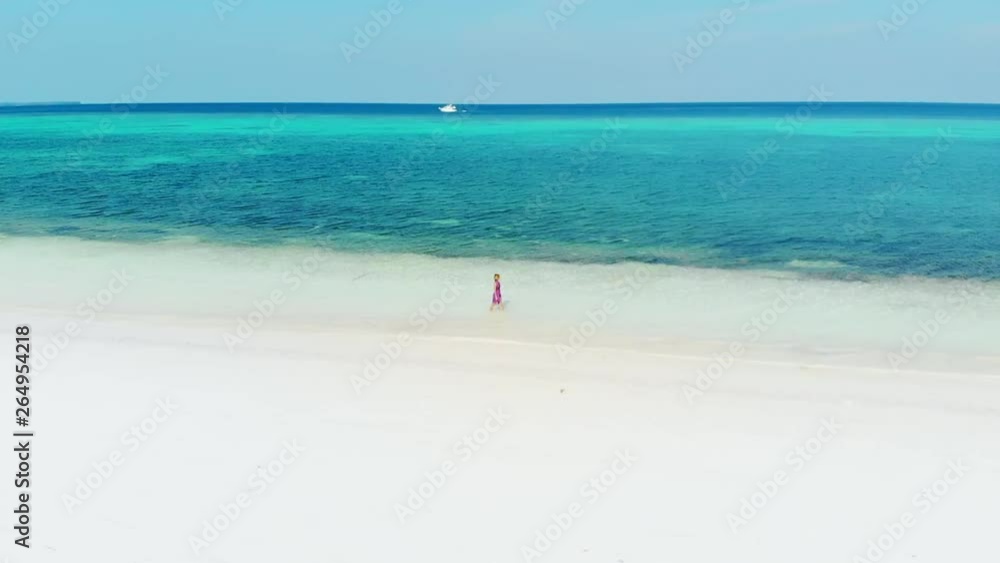 Aerial slow motion: woman walking on white sand tropical beach turquoise water coral reef Pasir Panjang Kei Islands Maluku Moluccas archipelago Indonesia Aerial slow motion: woman walking on white sand tropical beach turquoise water coral reef Pasir Panjang Kei Islands Maluku Moluccas archipelago Indonesia