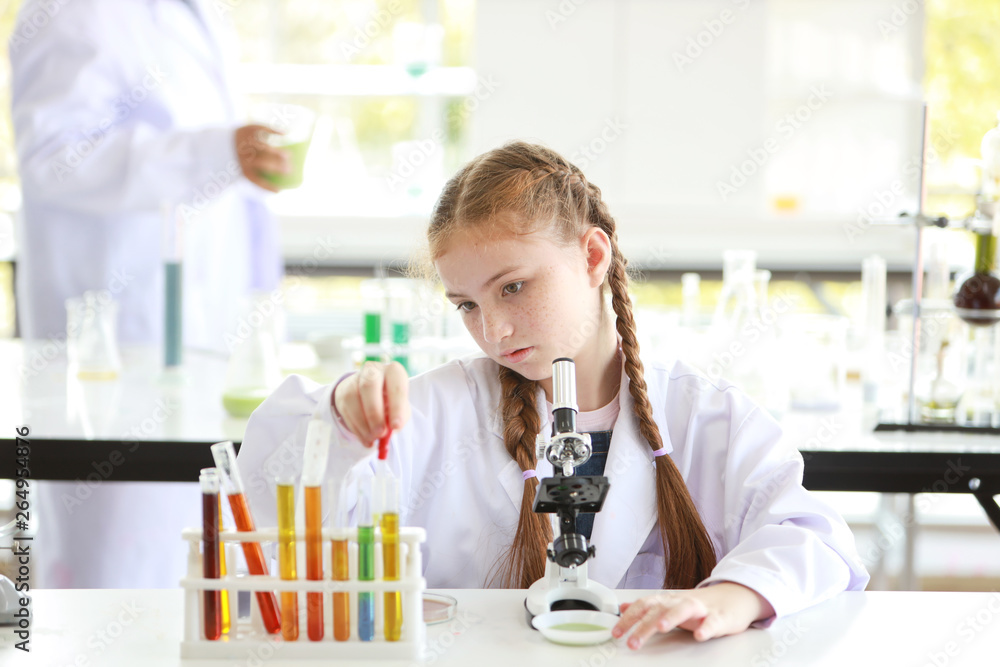 curious kid girl is experimenting science by dropping liquid into test tube with microscope and attention face (education and scientist concept) curious kid girl is experimenting science by dropping liquid into test tube with microscope and attention face (education and scientist concept)