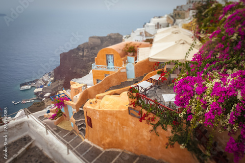Tilt shift effect of the village of Oia with flowering bougainvillea