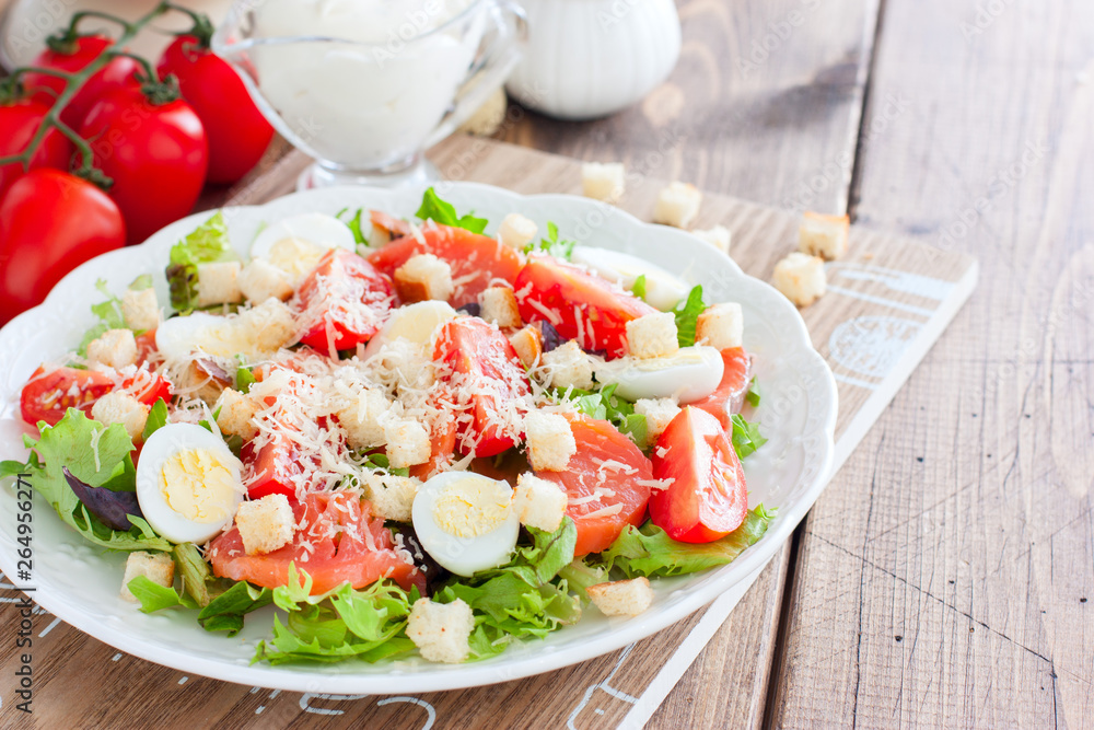 Caesar salad with salted salmon on a white plate, horizontal, copy space Caesar salad with salted salmon on a white plate, horizontal, copy space