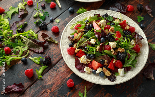 Fresh Fruit Salad with blueberry, strawberry raspberry, walnuts, feta cheese and green vegetables. healthy summer food