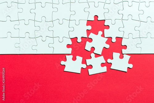 Red background made from white jigsaw puzzle pieces and place for your content photo