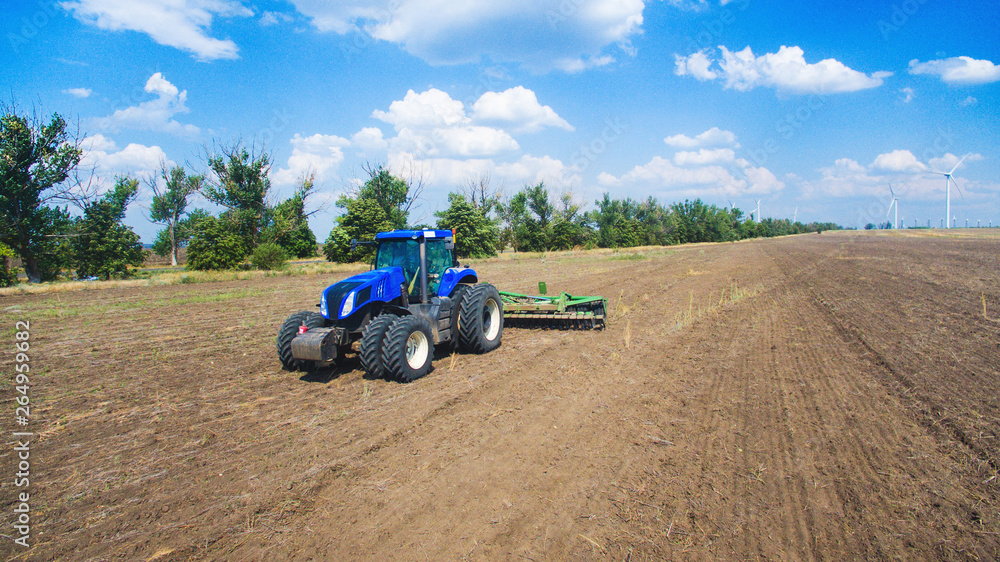A tractor plowing and sowing in the field