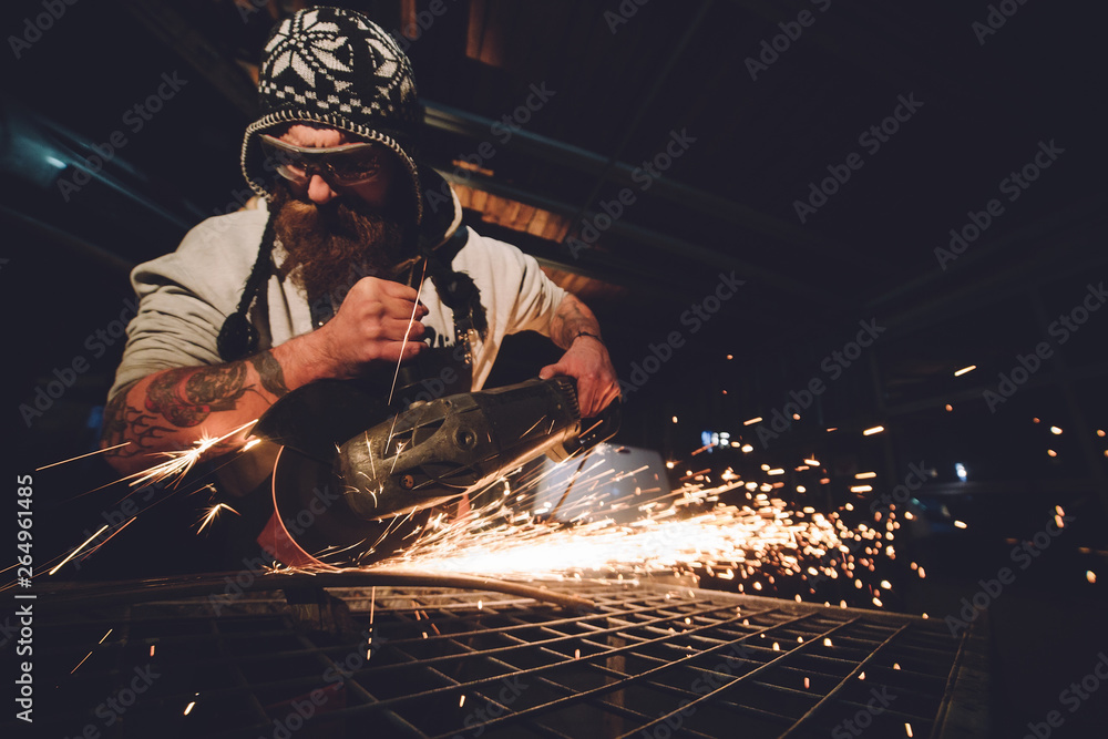 Worker Using Angle Grinder in Factory and throwing sparks - obrazy, fototapety, plakaty 
