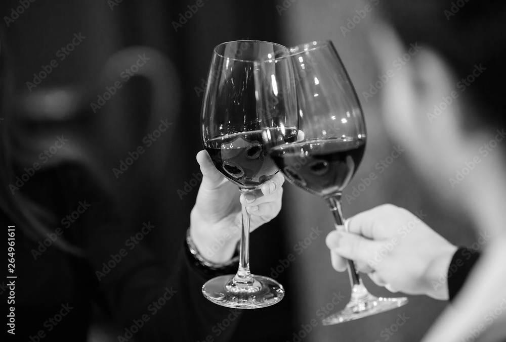 Man and woman drinking red wine. In the picture, closeup hands with glasses. Stock Photo