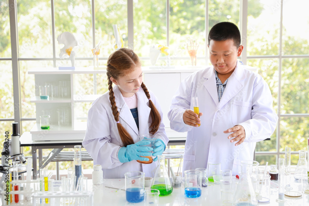 two happy kids making science experiments. (education and scientist concept) two happy kids making science experiments. (education and scientist concept)