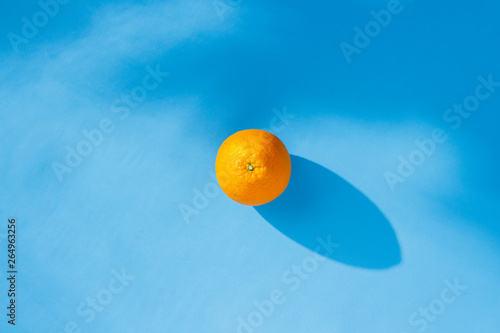 Orange on a blue background. Concept of vitamins, tropic, summertime. Natural light. Flat lay, top view.