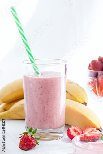 Smoothies of strawberries and bananas in glass glasses on a white table, selective focus