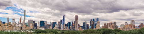 The beautiful New York City skyline with an interesting cloudy sky behind. Panorama of full skyline with all the famous towers and buildings.