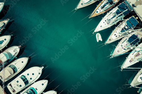 Aerial view of a lot of white boats and yachts moored in marina. Photo made by drone from above.