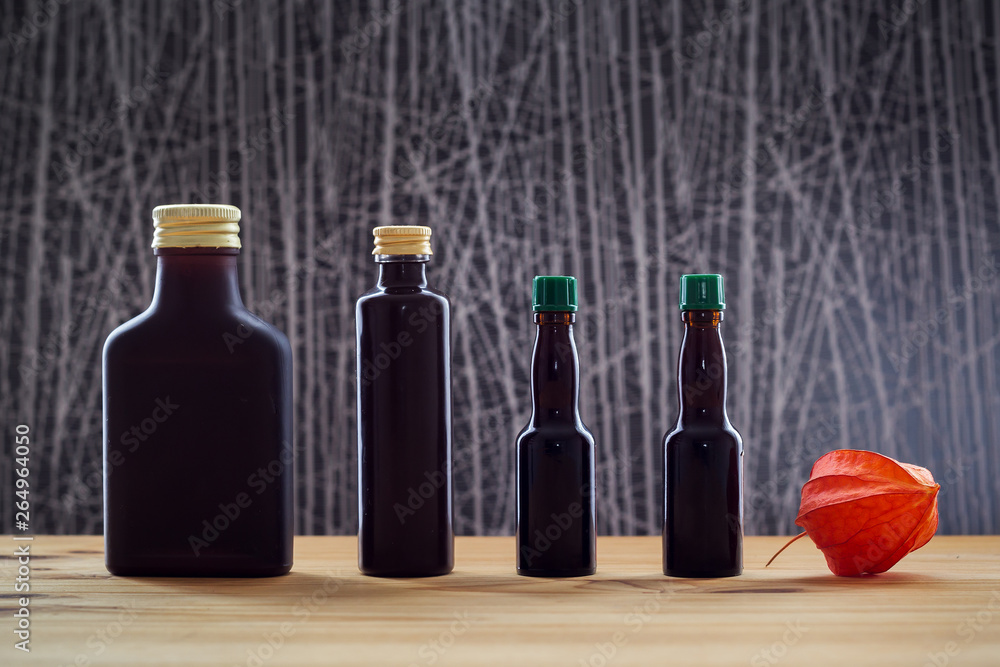 Four dark bottles and physalis Four dark bottles and physalis