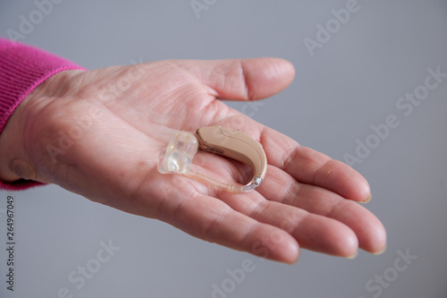 elderly retired with hearing impairment received hearing aid of latest modification in center of social protection. nurse helps to try hearing aid on. Help for seniors and people with disabilities © galitsin