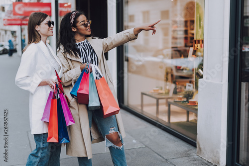 Valokuva Two beautiful women enjoying shopping and choosing what to buy together