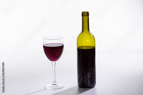 Glass and bottle with red wine on white background