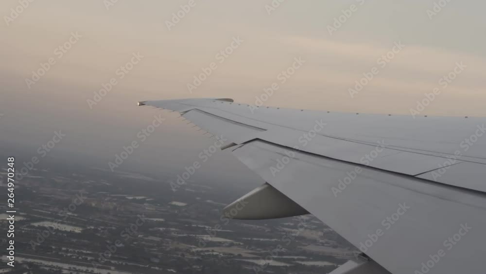 plane wing flying in the sky, view of sunset above city plan plane wing flying in the sky, view of sunset above city plan
