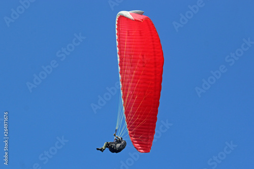Paraglider fying red wing