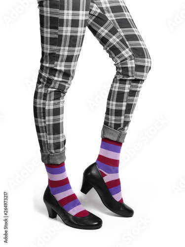 Women's legs in checkered jeans and funny striped socks. photo