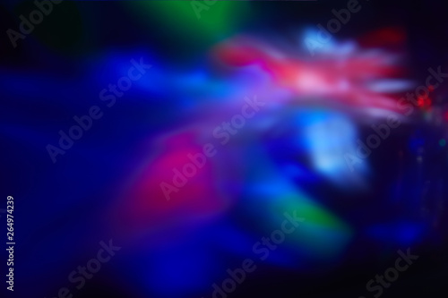 Multicolored blurred spots of light on a dark background.