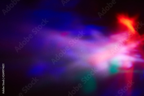 Blurry spots of light in green, blue, white and red