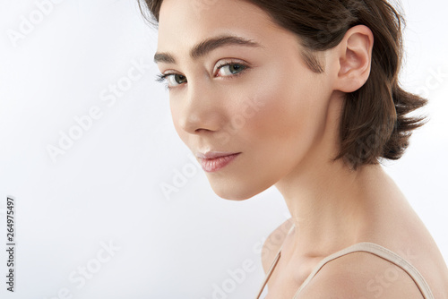Side on of graceful brunette female on white