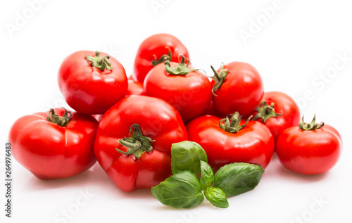 Fresh ripe tomatoes and basil on the white background