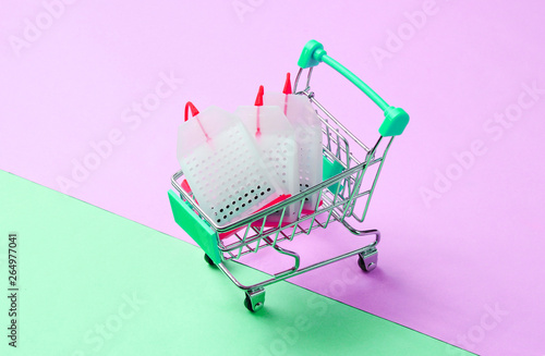 Tea bags in a toy shopping trolley on a pastel background. Conceptual photo.