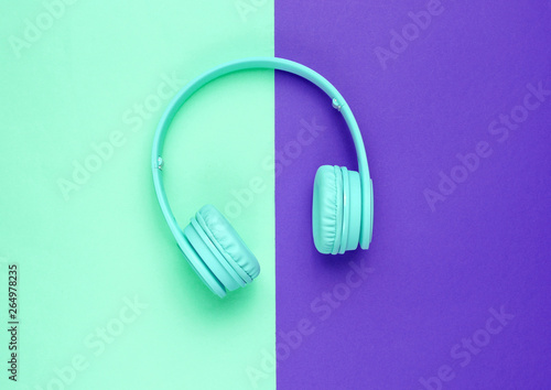 Modern Blue Wireless Over-Ear Headphones on a blue-purple background. Minimalism. Top view