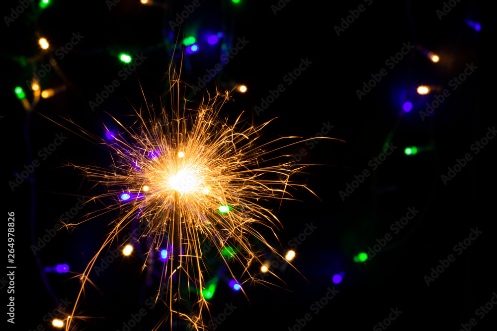 Obraz premium sparkler with blur new year's light close up