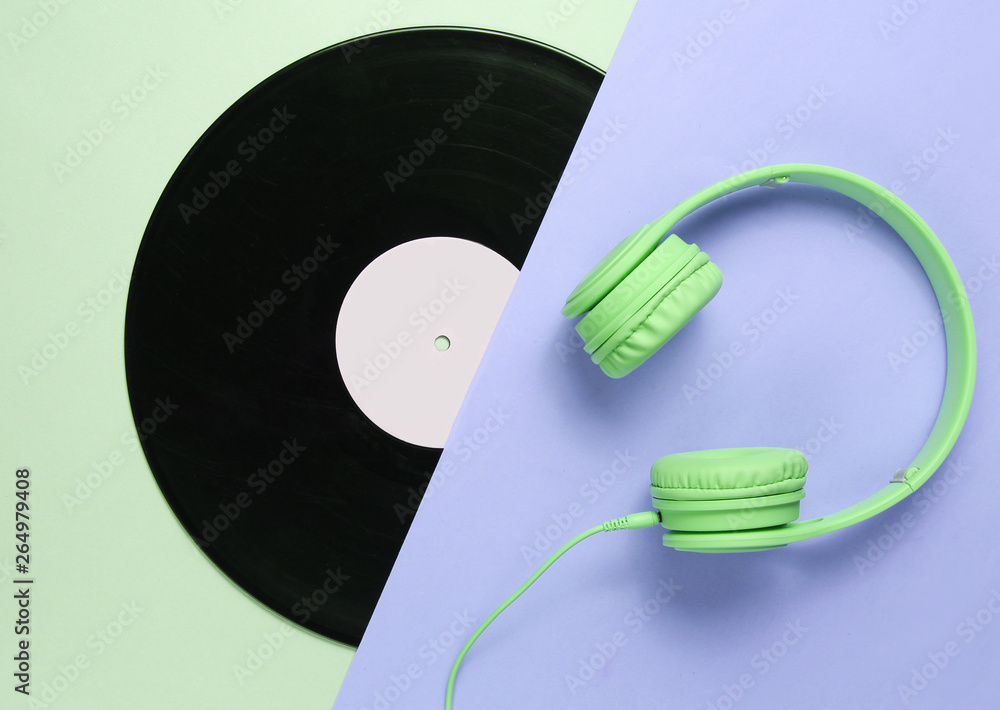 Retro 70s. Music lover. Headphones, lp record on green gray background. Flat lay. Top view. Retro 70s. Music lover. Headphones, lp record on green gray background. Flat lay. Top view.
