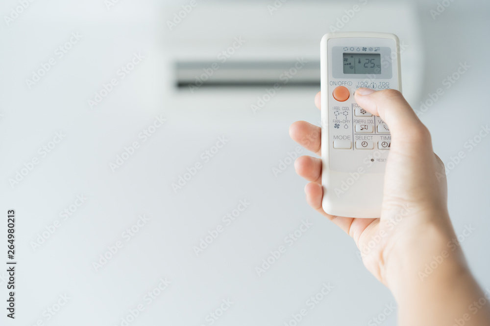 Woman hand using remote control open air conditioning 25 degrees. Open air 25 degrees, is temperature, save energy Woman hand using remote control open air conditioning 25 degrees. Open air 25 degrees, is temperature, save energy