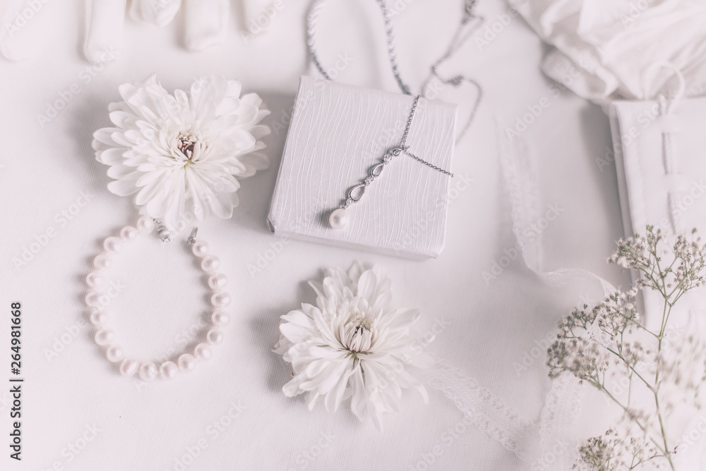 White bridal accessories for wedding background with pearls, white satin ribbons and lace, gloves, bracelet,flat lay for fashion blog, top view White bridal accessories for wedding background with pearls, white satin ribbons and lace, gloves, bracelet,flat lay for fashion blog, top view