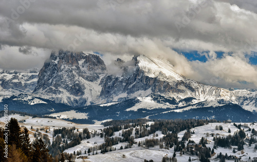 Winter panorama of italian ski resort with background of Seiser Alm, Alpe di Siusi, a high altitude alpine meadow in Dolomites with Langkofel and Plattkofel mountains under snow, South Tyrol, Italy.