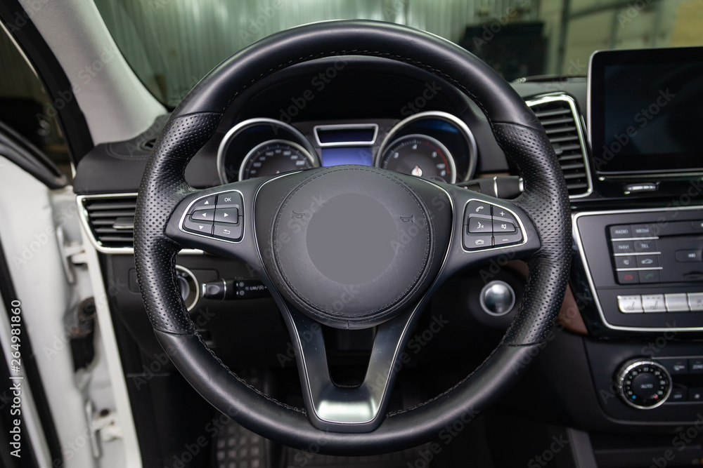 View to the black color interior of suv car with front seats, steering wheel and dashboard  with gray leather upholstery after cleaning and detailing in vehicle repair workshop. Auto service industry.