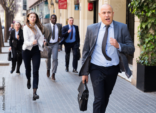 Fotografia Hurrying people with stressed man in foreground