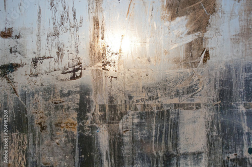 Abstract background. Window chaotically smeared with paint, illuminated by the sun.