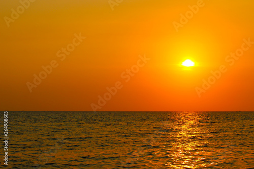 Bright sunset with large yellow sun above the sea surface. Last colors the day. Summer vacation and nature travel is adventure concept background. © Вера Тихонова