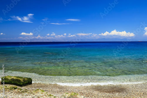 Picturesque summer beach, rocks in the surf line on a beautiful sea on Rhodes, Greece, travel, recreation, vacation concept. Sea background