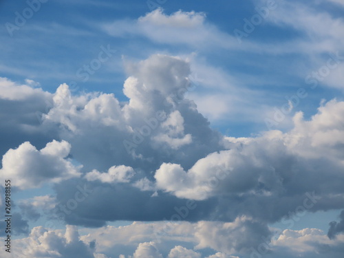 Soft white and grey stratocumulus clouds on a blue sky on a summer day before light rain