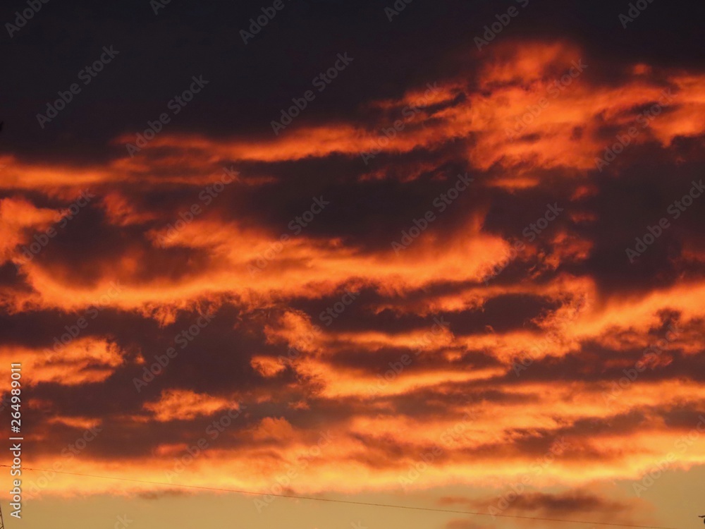 Dramatic dark clouds in sunset. Background with black, red, orange, yellow colors