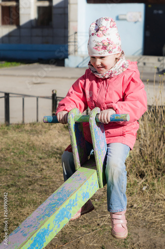 Little girl swinging on an old swing