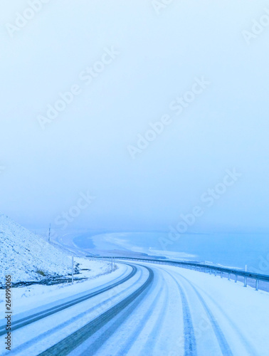 View of the icy road during the snowstorm in winter in Iceland.
