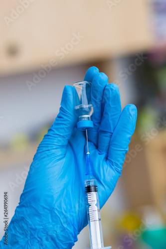 the veterinarian women with blue gloves preparing a vaccine