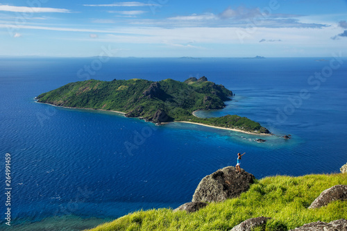 View of Kuata Island from Wayaseva Island with a hiker standing on a rock, Yasawas, Fiji photo