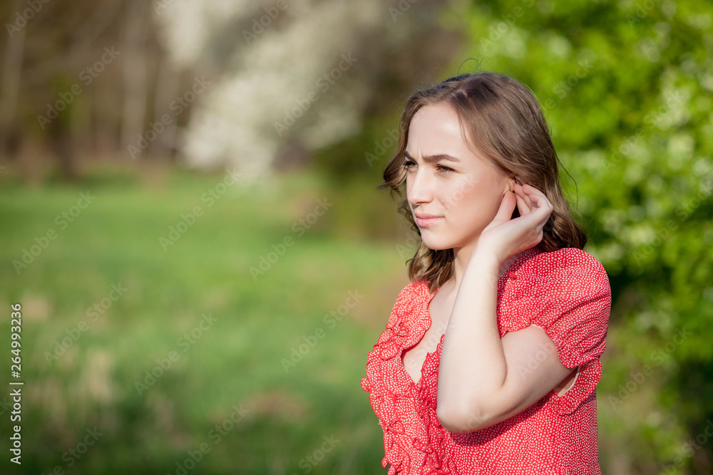 Close-up Of Female Hands Putting Hearing Aid In Ear. Modern digital in the ear hearing aid for deafness and the hard of hearing patients Close-up Of Female Hands Putting Hearing Aid In Ear. Modern digital in the ear hearing aid for deafness and the hard of hearing patients