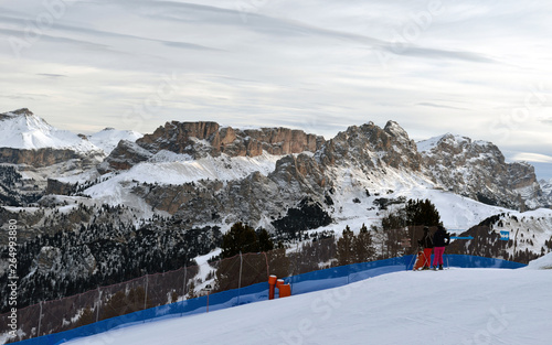 Skier going down the slope under ski lift at Sella Ronda ski route in Italy